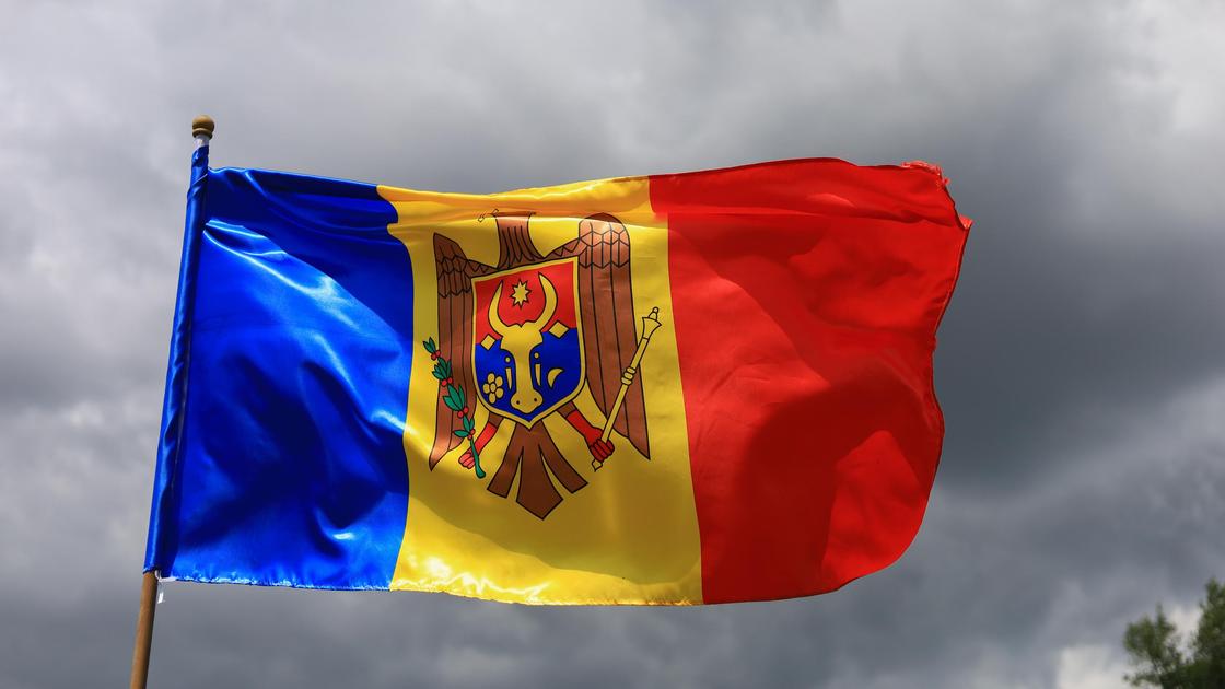 The official flag of the state of the Republic of Moldova against the sky